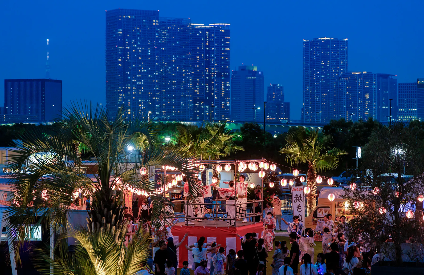 キラナの大夏祭り2026 夜の会場に提灯が並び、豊洲のタワーマンション群を背景に縁日屋台が賑わう様子