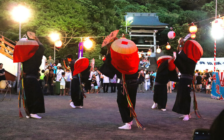 新島・若郷の大踊。赤いカバを垂らした笠をかぶり黒い紋服姿で踊る踊り手たち