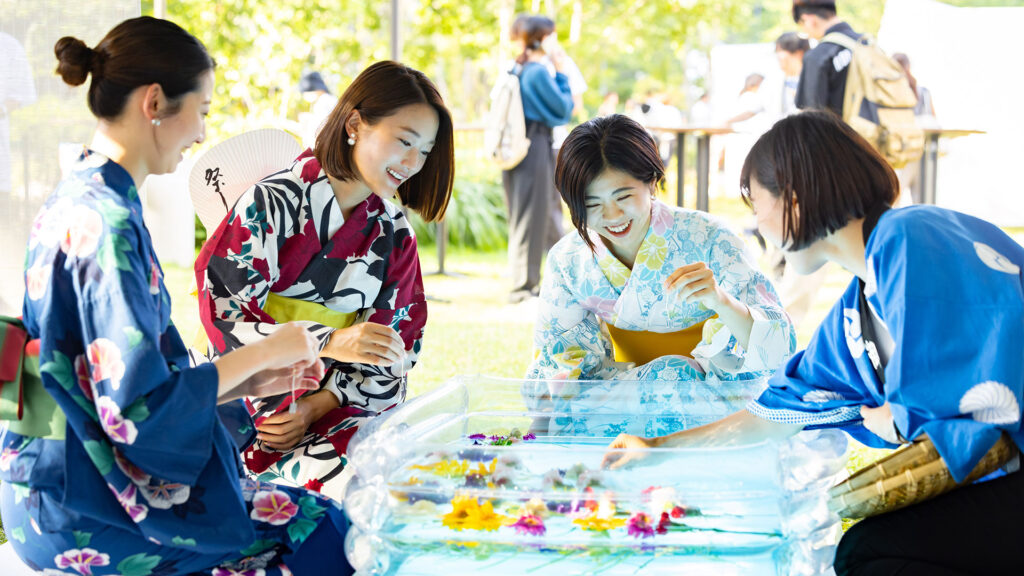 浴衣姿の女性たちがお花釣りを楽しむ麻布台ヒルズ納涼祭り2026の公式写真