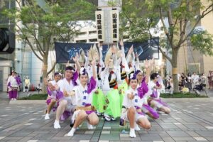 目黒銀座連の提灯を背に、子どもを含む阿波おどりの踊り手がポーズを取る様子