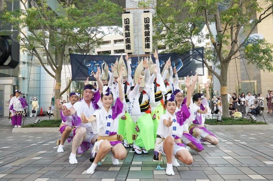 目黒銀座連の提灯を背に、子どもを含む阿波おどりの踊り手がポーズを取る様子