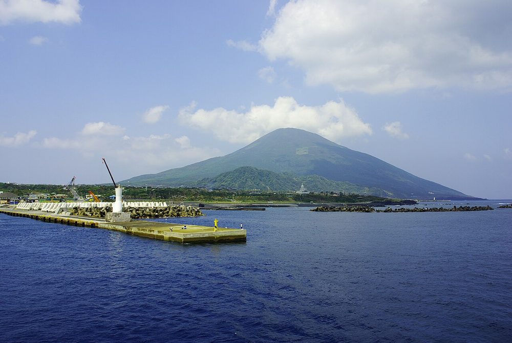 防波堤の先に八丈富士がそびえる底土港の昼の風景