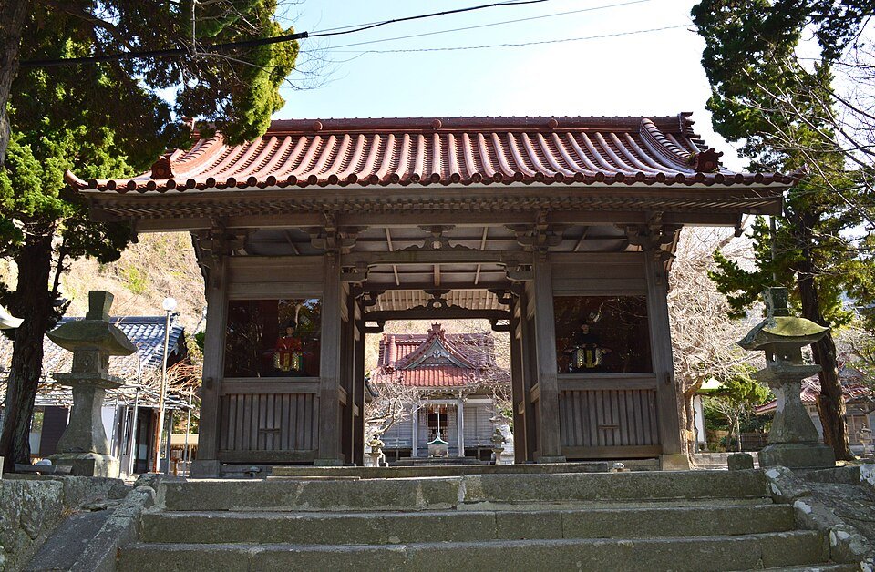 左右に随神像を納めた物忌奈命神社の随神門と、門越しに見える社殿