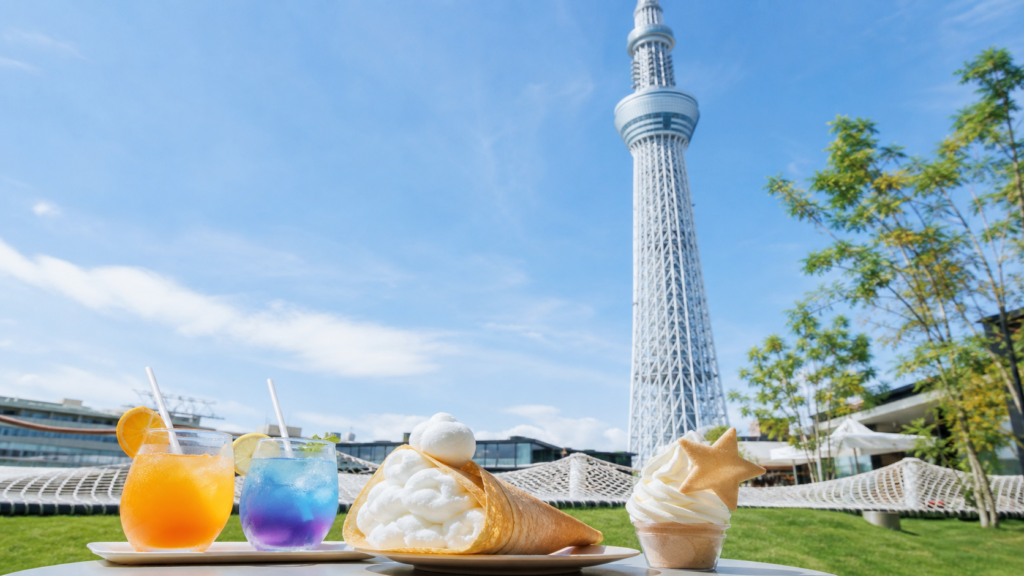 東京スカイツリーを背景にカラフルなドリンクとクレープを楽しむカフェのイメージ