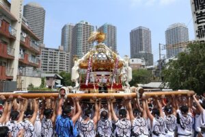高層マンションを背に担ぎ上げられる佃祭の八角神輿