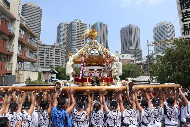 高層マンションを背に担ぎ上げられる佃祭の八角神輿