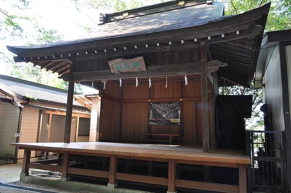 穴澤天神社の神楽殿。木造の舞台に「神楽殿」の扁額が掲げられ、紙垂の下がった正面が開いている