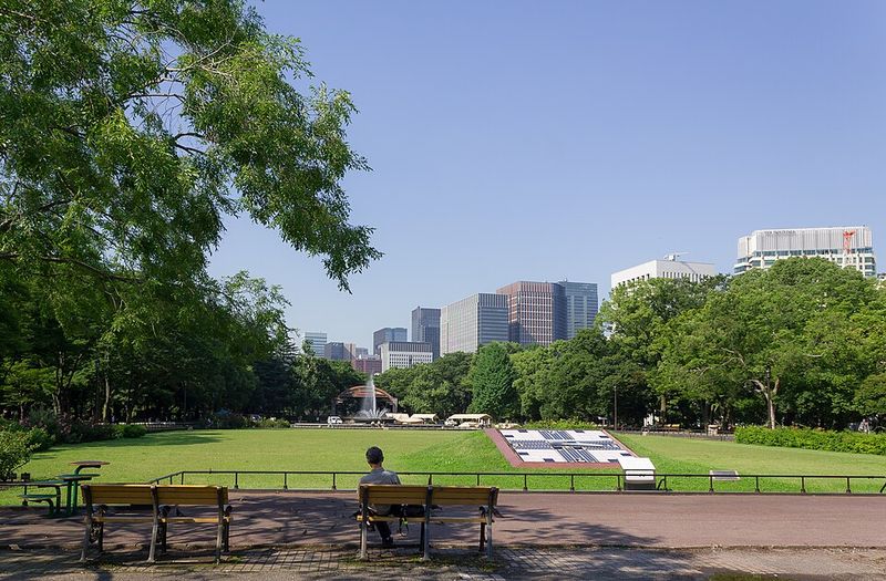 日比谷公園の第二花壇と、ベンチに座る人、奥に大噴水