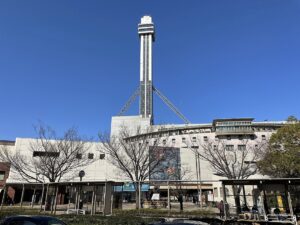 船堀駅の駅舎と、その背後に立つタワーホール船堀の展望塔。駅前にバス停の上屋が並ぶ