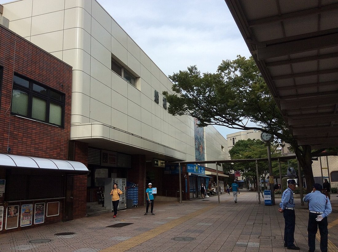 船堀駅前の広場。駅舎の前にバス停の上屋が並び、係員や利用者が歩いている