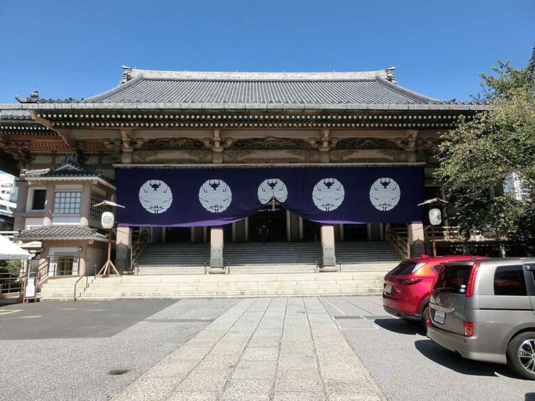 東本願寺（台東区西浅草）の本堂。瓦屋根の下に、白い紋を並べた紫の幕が張られている