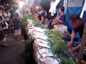 葉付きの生姜が束で山積みされた露店