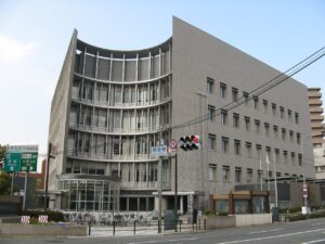 歌島橋交差点に面した大阪市西淀川区役所の庁舎。前面に駐輪スペースがある