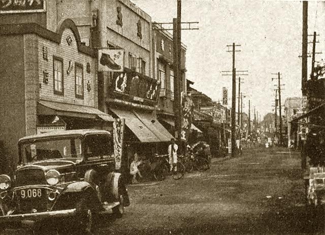 1932年の大岡山の商店街。看板建築が並ぶ通りと自動車