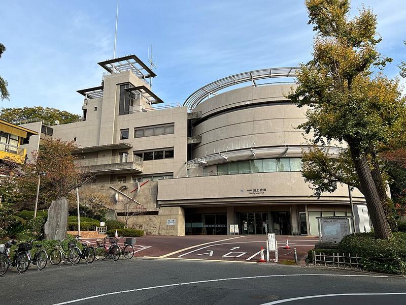 大田区立池上会館の外観。円筒形の吹き抜けを持つ鉄筋コンクリートの建物と、正面のロータリー