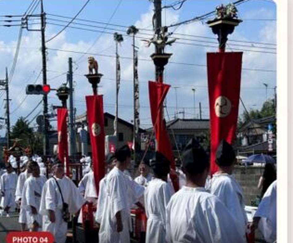 白装束の氏子が赤い幟や榊を立てた御神幸行列となって、昼の街道を静かに進んでいる