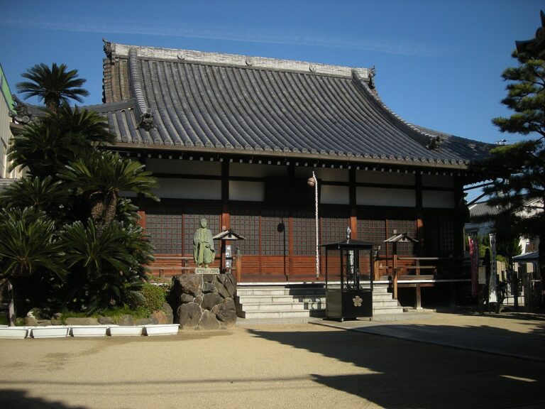 大阪市此花区の伝法山西念寺の本堂と、前庭に立つ僧形の石像
